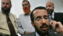 Palestinian minister for Jerusalem affairs in the Hamas-led government Khaled Abu Arafa, speaks on his mobile phone while Hamas lawmakers, from right to left, Ahmed Abu Atoun, Mohammed Abu Teir, Mohammed Totach gather inside the Palestinian Legislative Council building in the West Bank town of Ramallah,Tuesday, May 30, 2006. Israel's interior minister on Monday informed four Hamas legislators from east Jerusalem that they must renounce their membership in the militant Islamic group if they were to continue to have residency rights in Israel-controlled Jerusalem. Interior Minister Ronnie Bar-On issued the ultimatum to Mohammed Abu Teir, Ahmed Abu Atoun, Khaled Abu Arafa and Mahmoud Totach. (AP Photo/Muhammed Muheisen)